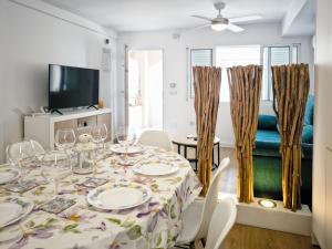 a dining room with a table and chairs and a tv at Seaside Terraced Bungalow in La Mata in La Mata