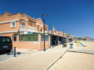 a street with buildings and a person playing with a frisbee at Seaside Terraced Bungalow in La Mata in La Mata