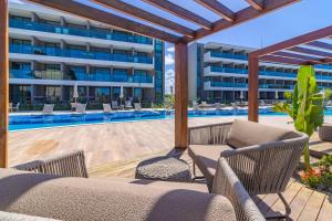 an outdoor patio with chairs and a swimming pool at Beach Class Summer resort condominium by Carpediem in Porto De Galinhas +171 photos