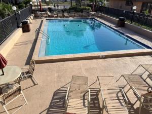 a large swimming pool with chairs and a table at El Galeon 3BR – Bay Views, Beach, Boat Dock in Punta Gorda Beach