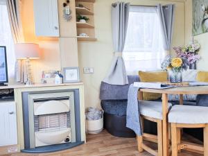 ein Wohnzimmer mit Kamin und Tisch in der Unterkunft Ocean Breeze in Truro