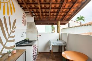 an outdoor kitchen with a sink and a stove at Casa Tupi - suítes no coração do Itaguá em Ubatuba in Ubatuba