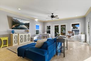 a living room with a blue couch and a table at Luxury Lakefront Escape w/ Heated Pool, Hot Tub & Theater in Sunrise Beach