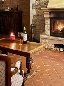 a table with a bottle of wine and a candle at Dwór Strzyżew in Żelazowa Wola +64 photos