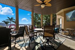 a patio with chairs and tables and a ceiling fan at Luxury Lakefront Escape w/ Heated Pool, Hot Tub & Theater in Sunrise Beach
