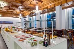 ロッテルダムにあるNH アトランタ ロッテルダム ホテルのさまざまな種類の食べ物が並ぶビュッフェライン +31枚の写真