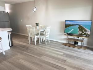 a dining room with a table and a tv at El Galeon – Bay Views, Beach Access & Pool in Punta Gorda Beach