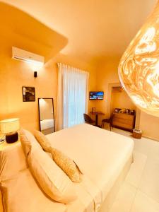 una camera da letto con un letto bianco e un divano di Bìfara Rooms a Palermo