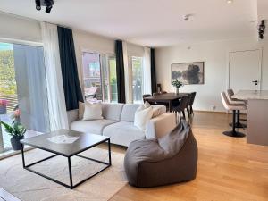 a living room with a couch and a table at Large luxurious apartment with private terrace and parking in Bergen