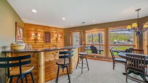 a kitchen with wooden walls and a bar with chairs at Hot Tub, Fire Pit, Awesome Loft & Amazing Views! in Buck Creek