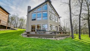 a house with a large window on a green lawn at Hot Tub, Fire Pit, Awesome Loft & Amazing Views! in Buck Creek
