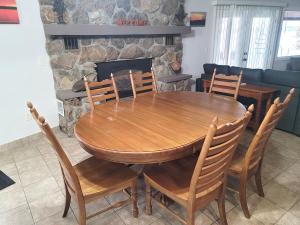 un tavolo e sedie in legno nel soggiorno con camino di Newly Updated Interior, Sunroom w/ Hot Tub, Deck, Deep Water Dock, Boat & PWC Slips a Buck Creek