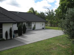 a driveway leading to a house with a garage at Karapiro Willows Luxury B & B in Cambridge