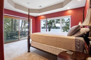 a bedroom with red walls and a bed with a table at Pet-Friendly Home In The Main Channel w/ Breathtaking Sunsets & Lake Views in Lake Ozark