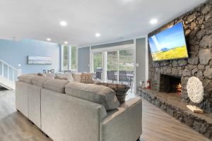 a living room with a large couch and a fireplace at Our Cove Retreat - Perfect for Wave-Free Swimming, Tanning & Prime Location Fun! in Lake Ozark