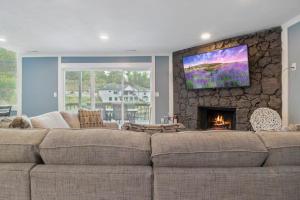 a living room with a large couch and a fireplace at Our Cove Retreat - Perfect for Wave-Free Swimming, Tanning & Prime Location Fun! in Lake Ozark +34 photos