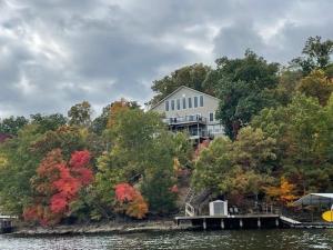 een groot huis aan de oever van een meer bij Lakefront Home w/ Double Deck, Slip, Firepit & Game Room in Sunrise Beach