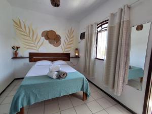 a bedroom with a bed with two towels on it at Odoyá Casa Hostel in Arraial d'Ajuda