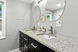 een badkamer met een wastafel en een spiegel bij Lakefront Home w/ Double Deck, Slip, Firepit & Game Room in Sunrise Beach +77 foto's