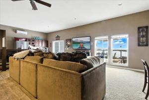 een woonkamer met banken bij Lakefront Home w/ Double Deck, Slip, Firepit & Game Room in Sunrise Beach