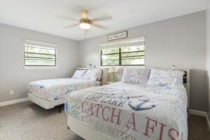 a bedroom with two beds and a ceiling fan at Spacious, Central Location, Fire Pit, Boat Slip in Lake Ozark