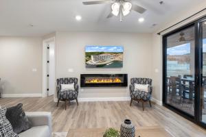 a living room with a fireplace and two chairs at Topsider Experience in the Heart of Osage Beach in Laguna Beach