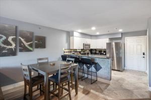 eine Küche mit Tisch und Stühlen und einer Theke in der Unterkunft Lakeview Condo w/ 2 Pools & Beach - Family Fun Awaits at 21MM in Laguna Beach