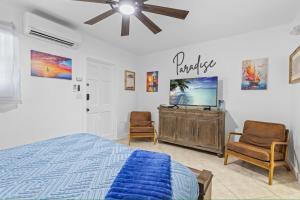 a bedroom with a bed and a tv and two chairs at Sailors Cabin - Prime Downtown Key West Spot - Walk to Duval in Key West