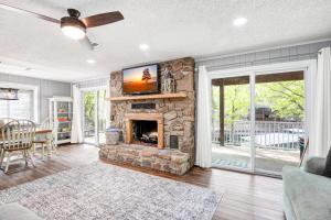 ein Wohnzimmer mit einem Steinkamin und einem TV in der Unterkunft Stunning Views of the 75mm, Private Dock, Spacious Decks, Kayaks & More! in Buck Creek