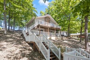 ein Haus auf einem Hügel mit Treppen, die hinaufführen in der Unterkunft Stunning Views of the 75mm, Private Dock, Spacious Decks, Kayaks & More! in Buck Creek