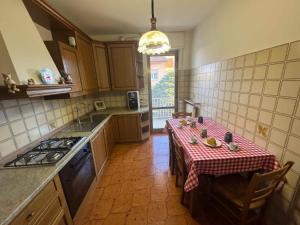 a kitchen with a table with a red and white table cloth at Appartamento La Coccinella in Gonàrs