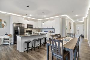 a kitchen with white cabinets and a table and chairs at Topsider Condo w/ Updated Design & Amazing Main Channel Views in Laguna Beach