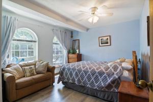a bedroom with a bed and a couch at Wonderful Remote Lake Cabin! Fish from Deck & Dock in Rocky Mount