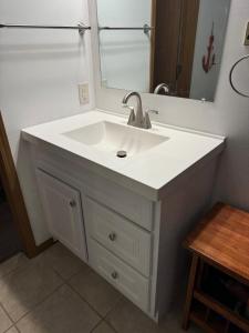 a bathroom with a white sink and a mirror at Wonderful Remote Lake Cabin! Fish from Deck & Dock in Rocky Mount