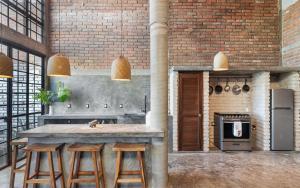 プンタ・ミタにあるSummer Salt Beach Casitaのレンガの壁、カウンターとスツール付きのキッチンが備わります。