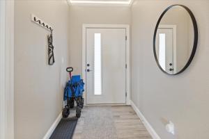 Ein Flur mit einem Spiegel und einem Kinderwagen vor einer Tür in der Unterkunft Lakefront Topsider Condo w/ Boat Slip, 2 Pools & Large Deck in Laguna Beach