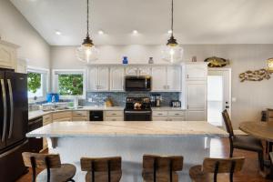 eine Küche mit weißen Schränken und eine große Insel mit Stühlen in der Unterkunft Incredible Views, Spacious Deck, Private Dock, Gas Grill, Games & Cards in Buck Creek + 38 Fotos