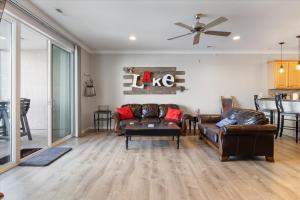 a living room with leather furniture and a ceiling fan at Lands End Condo with Amazing Main Channel Views, 2 Pools, Playground & Boat Slip in Laguna Beach