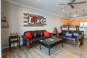 a living room with two leather couches and a table at Lands End Condo with Amazing Main Channel Views, 2 Pools, Playground & Boat Slip in Laguna Beach