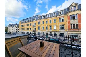 a wooden table on a balcony with a building at LUMA Apartments in Dresden
