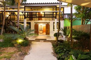 ein Haus mit einem Weg, der zur Eingangstür führt in der Unterkunft Kata Tranquil Villa - SHA Plus in Karon Beach