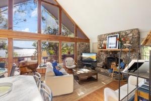 ein Wohnzimmer mit einem großen Raum mit einem Steinkamin in der Unterkunft Woodmont Point - Wooded Private Lakefront Retreat with Deep Cove Dock and Great Swimming! in Purvis