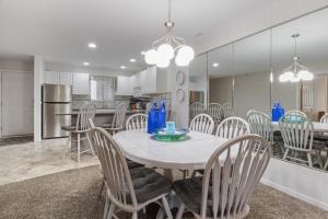 a kitchen and dining room with a white table and chairs at LazyDays Pet-Friendly Condo w/ Pool & Slip at 3M in Damsel