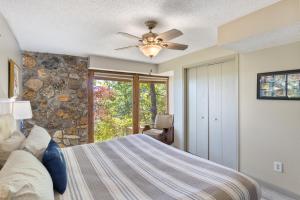 ein Schlafzimmer mit einem Bett und einem Deckenventilator in der Unterkunft Woodmont Point - Wooded Private Lakefront Retreat with Deep Cove Dock and Great Swimming! in Purvis