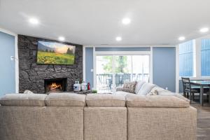 a living room with a large couch and a fireplace at Our Cove Retreat - Perfect for Wave-Free Swimming, Tanning & Prime Location Fun! in Lake Ozark