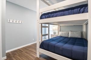 a bedroom with a bunk bed with blue sheets at Our Cove Retreat - Perfect for Wave-Free Swimming, Tanning & Prime Location Fun! in Lake Ozark