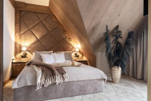 een slaapkamer met een groot bed en een houten plafond bij Willa Tatrzańska Luxury Apartments & Spa in Murzasichle