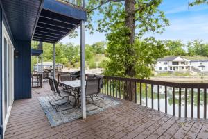 a patio with a table and chairs on a deck at Our Cove Retreat - Perfect for Wave-Free Swimming, Tanning & Prime Location Fun! in Lake Ozark