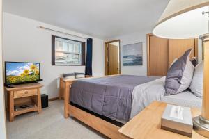 a bedroom with a bed and a tv and a table at Spacious, Quiet & Great Cove, Nearby Attractions, Private Dock, Fireplace, Expansive Deck in Rocky Mount