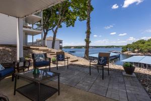 a patio with chairs and tables and a view of the water at Pet-Friendly Condo at MM-19 w/ Boat Slip & Lake Views in Laguna Beach